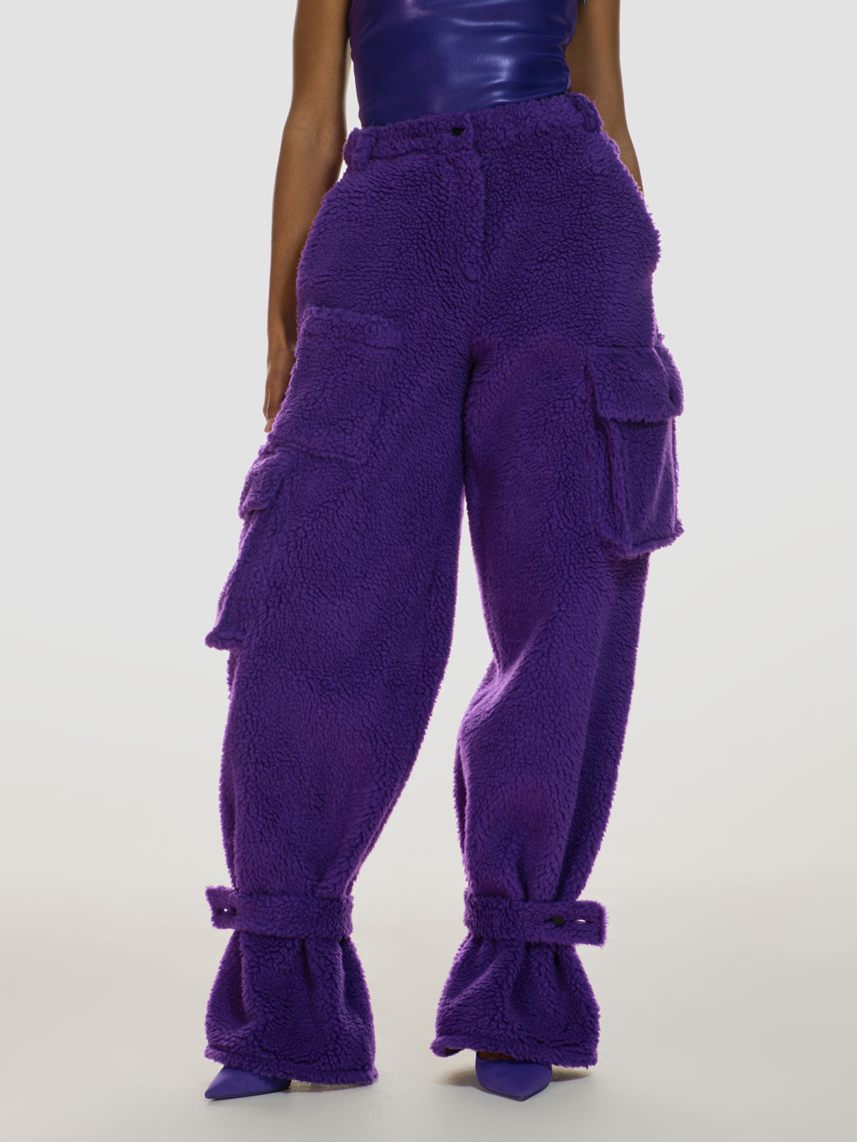 Medium full shot of a girl wearing a purple vegan leather tube top and purple polar fleece cargo pants