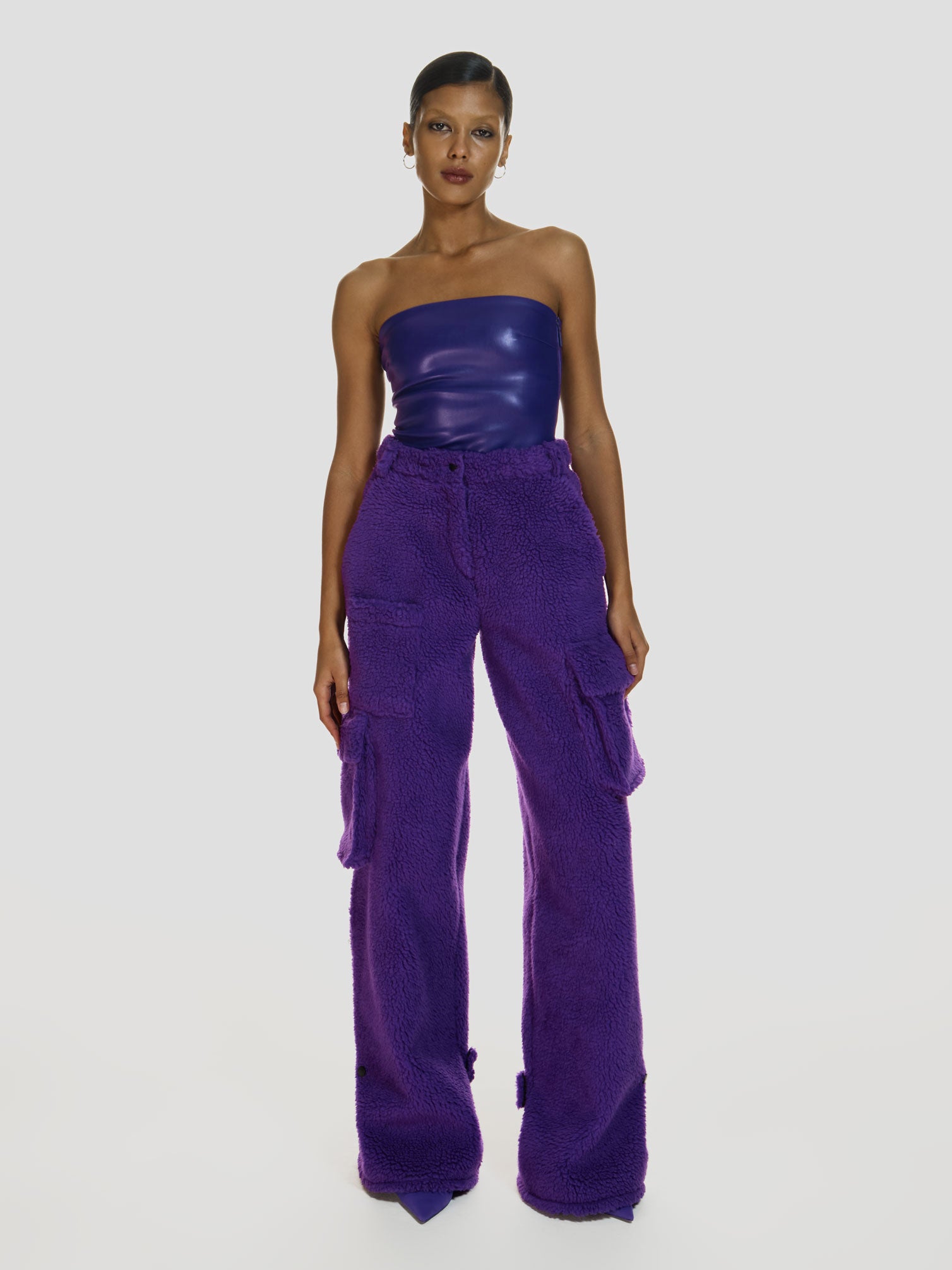 Full shot of a girl in a purple vegan leather tube top and purple polar fleece cargo pants