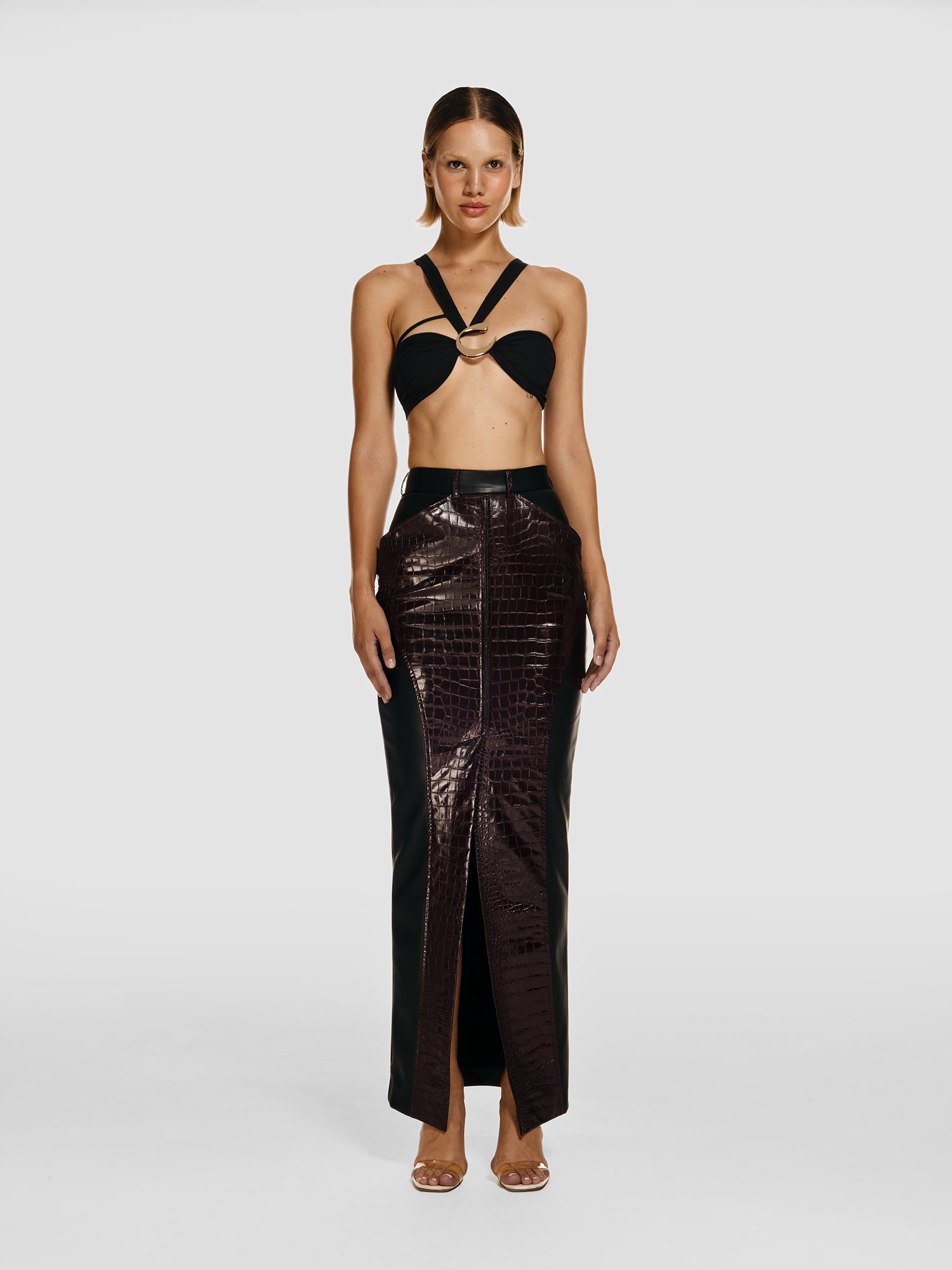 Full shot of a girl in a black viscose crop top and a black vegan leather maxi skirt with a plum vegan crocodile printed leather insert with and high front slit