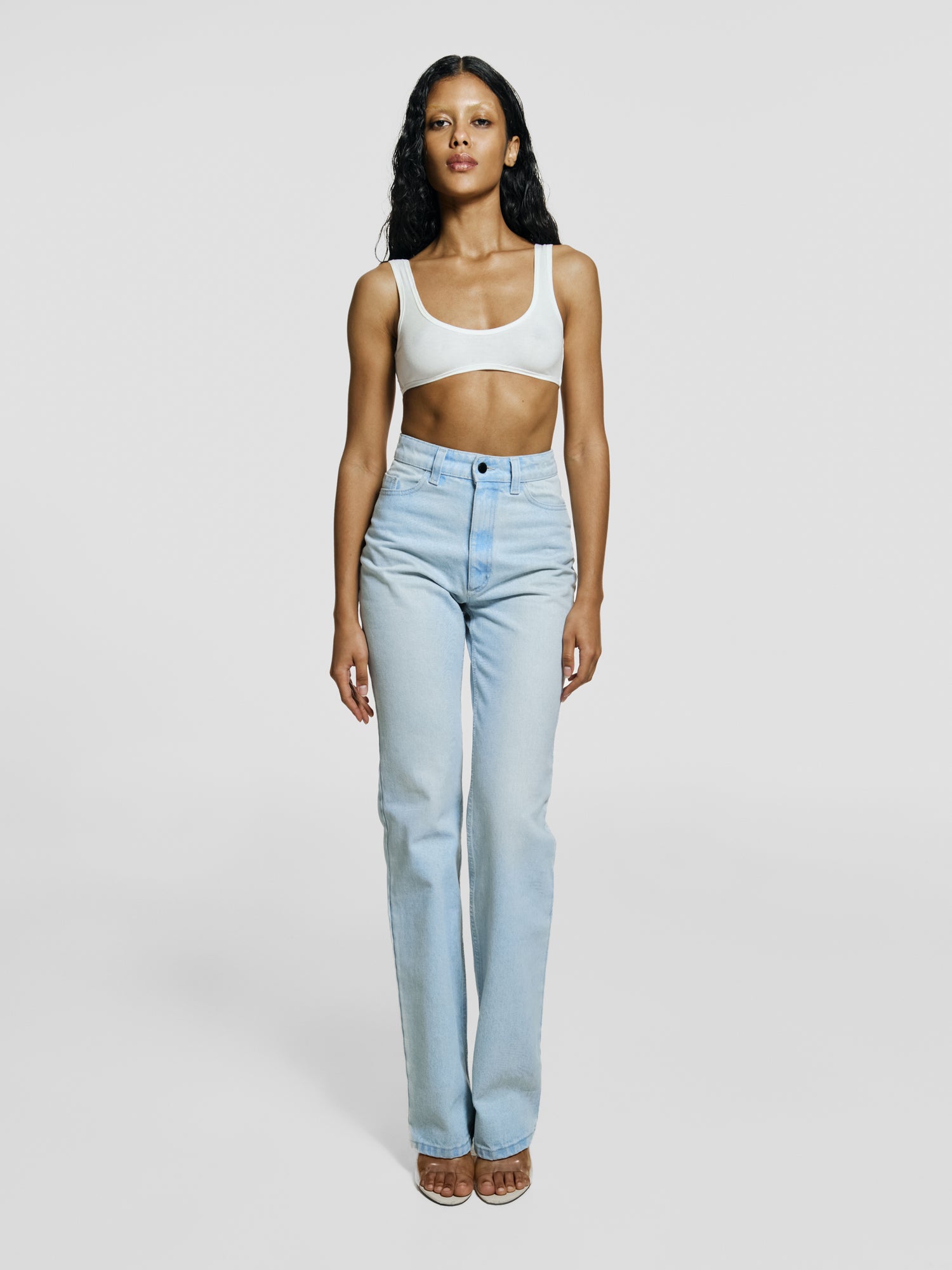 Full shot of a girl in white viscose crop top and in blue high rise straight leg jeans