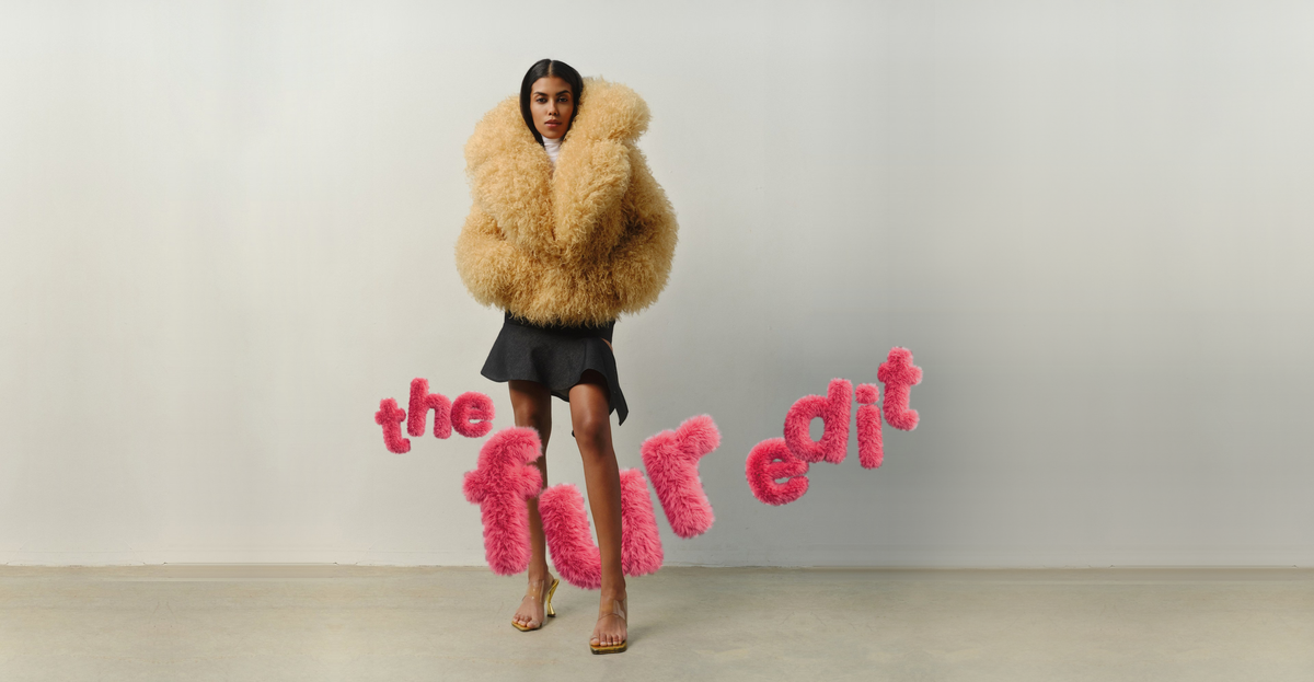 The fur edit: model in a curly sand faux fur coat with pink fur lettering