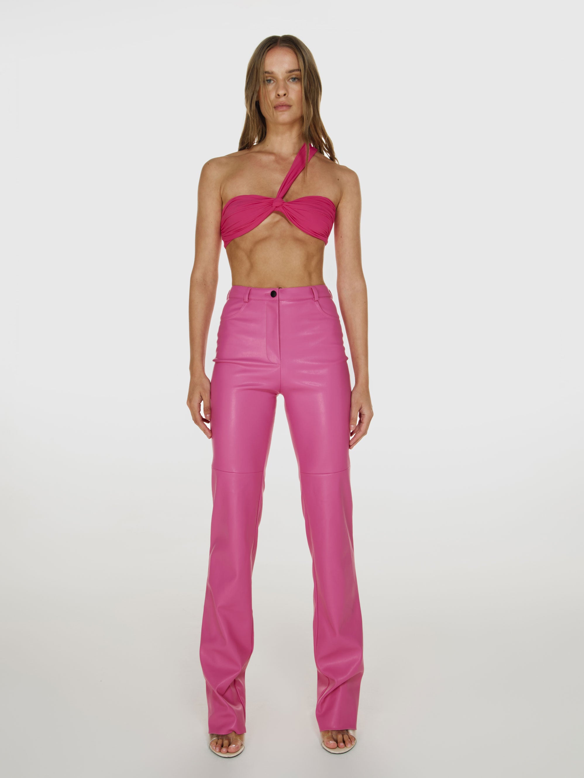 Full shot of a girl in a pink one shoulder crop top and pink vegan leather pants with straight leg