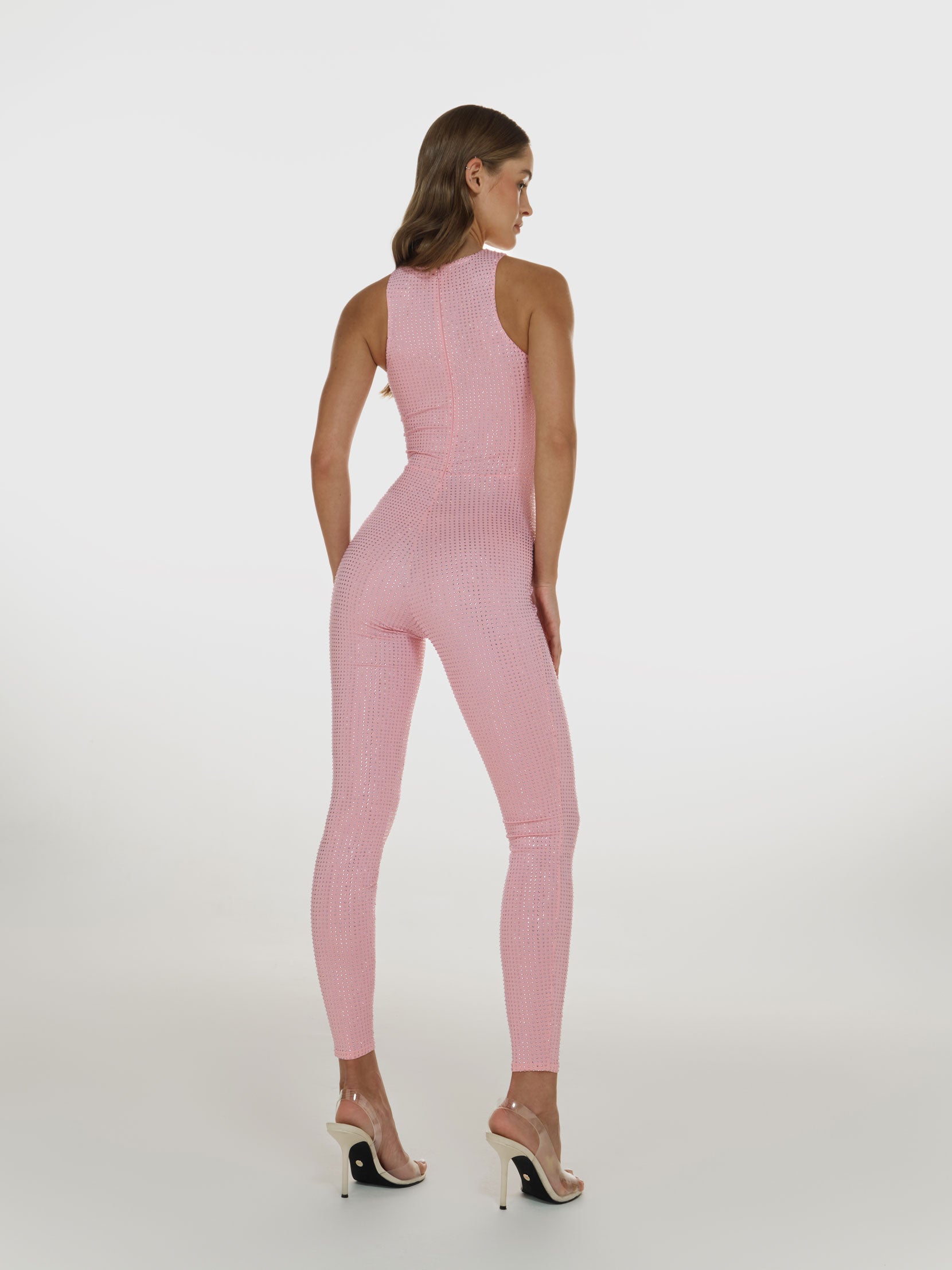 Full shot of a girl facing back in a pink sleeveless jumpsuit decorated with Swarovski crystals