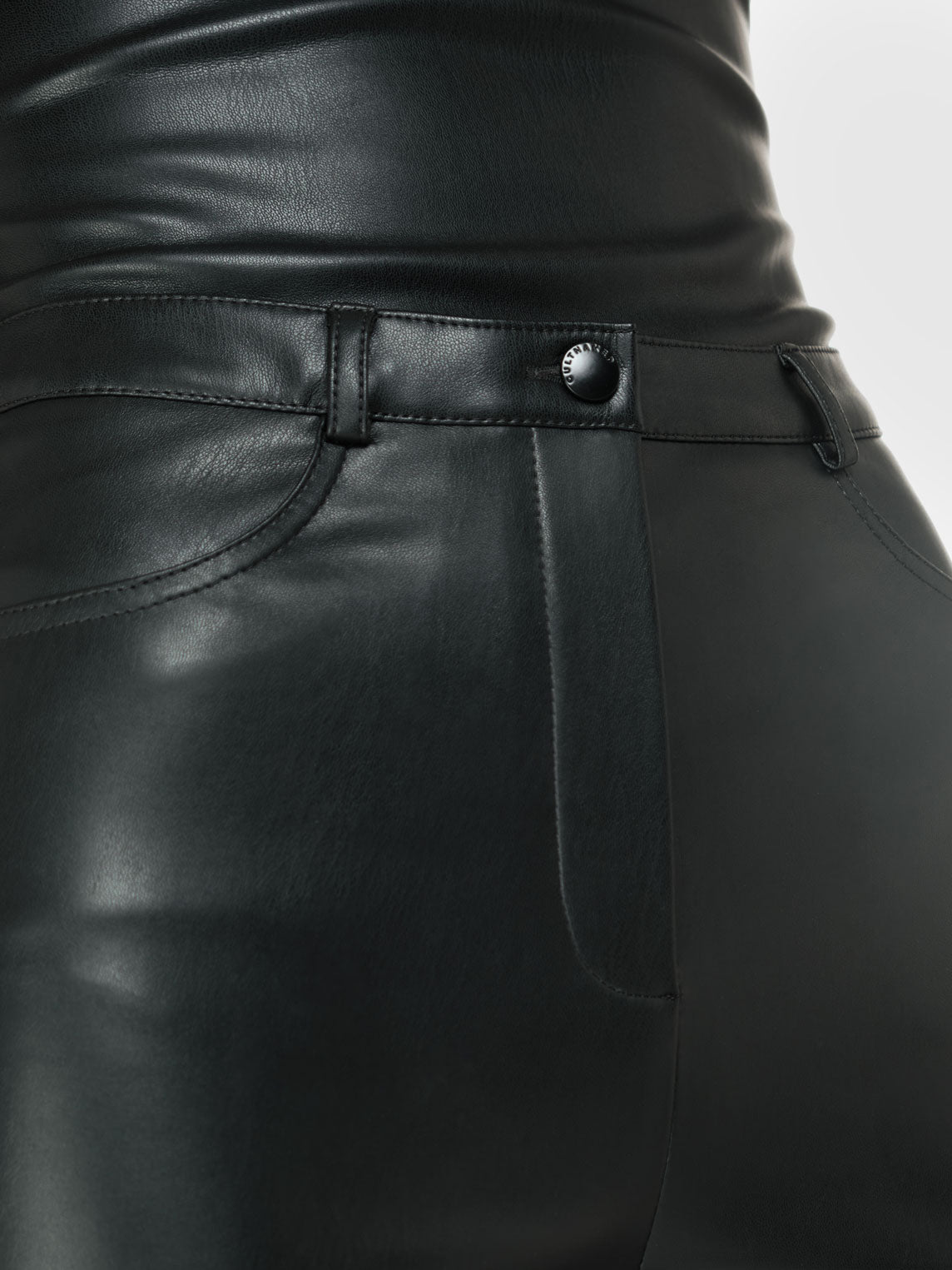 Closeup shot of a black vegan leather tube top and black vegan leather pants with straight leg