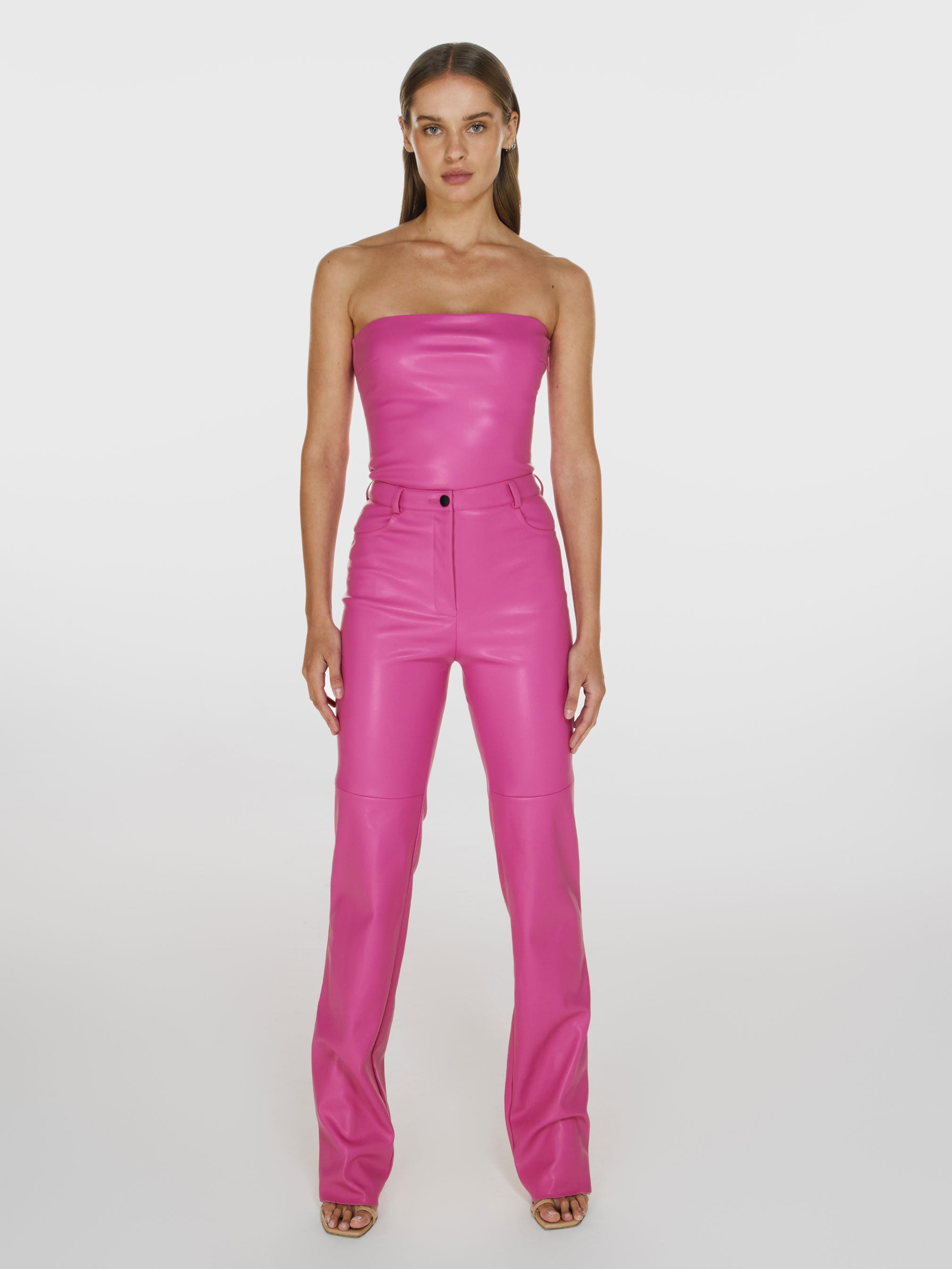 Full shot of a girl in a pink vegan leather tube top and pink vegan leather pants with straight leg