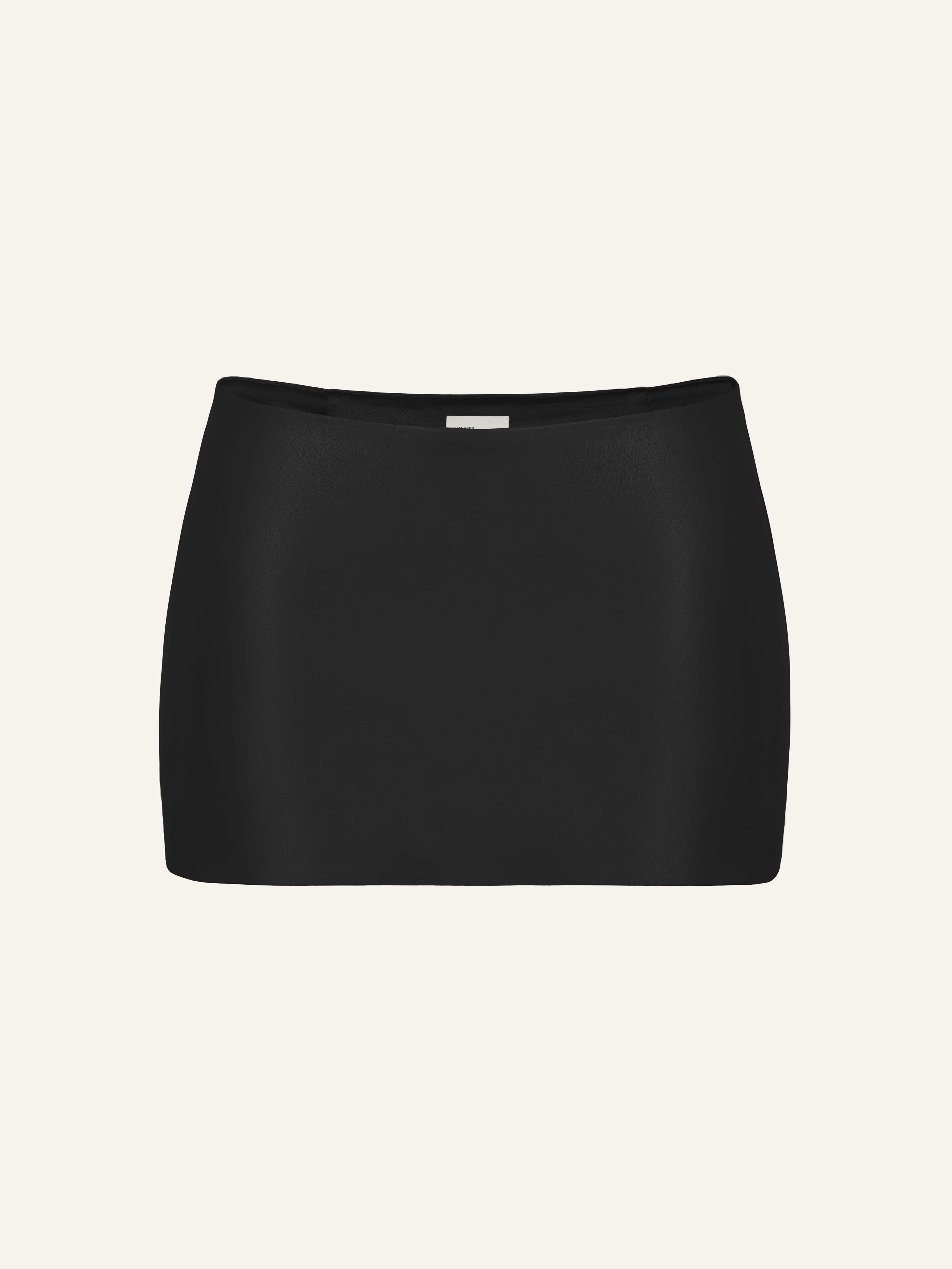Product photography of a black vegan leather low rise mini skort