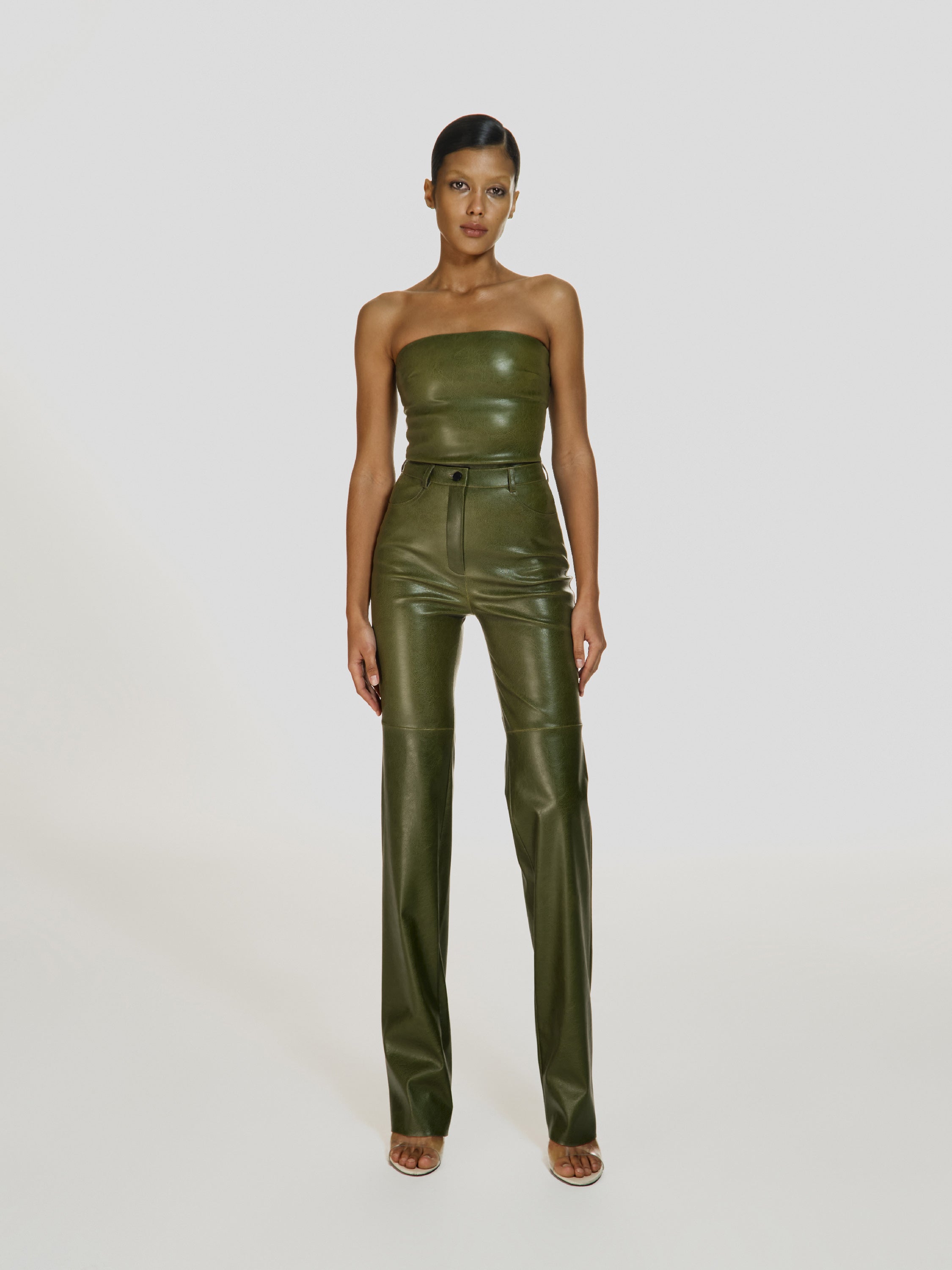 Full shot of a girl in a green vegan leather tube top and green vegan leather high rise pants with straight leg